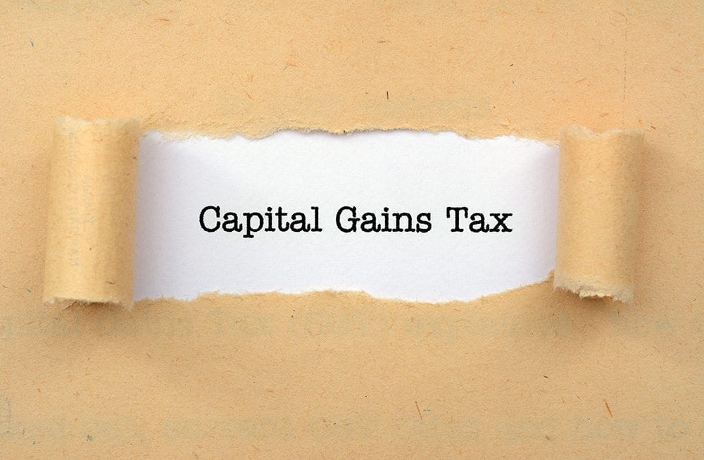 Image of a page being torn to show the words Capital Gains Tax